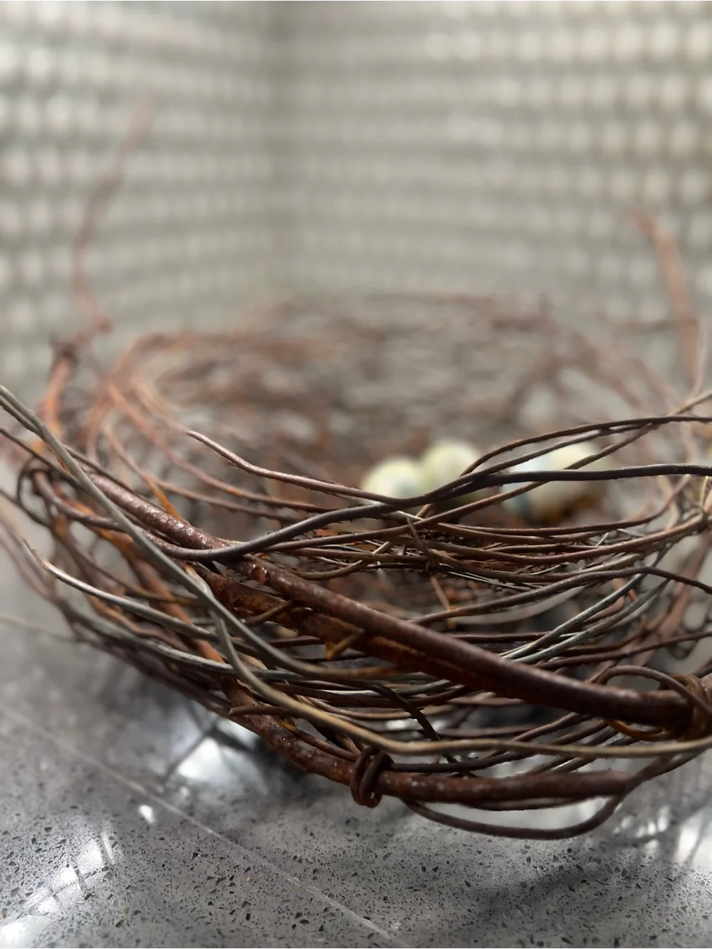 Metal rustic twig nest containing three artificial eggs decorative art
